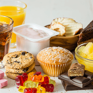 Unhealthy snack – muffin, cookies, gummy bears, chocolate, yoghurt, coke, juice.